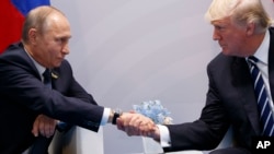 Presiden Rusia Vladimir Putin (kiri) saat bertemu Presiden AS Donald Trump di sela KTT G-20 di Hamburg, Jerman 7 Juli 2017 (foto: dok). Trump terus membantah adanya keterlibatan tim suksesnya dengan para pejabat Rusia. 