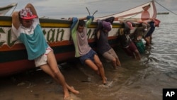 Fishermen from the Marval family bring their boat to shore after fishing all night, in Punta de Araya, Sucre state, Venezuela, Nov. 2, 2016. 