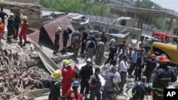 Des secouristes recherchent des victimes sur le site d'un attentat à la bombe dans le quartier central de Bab al-Muadham à Bagdad, en Irak, le lundi 4 Juin 2012. (AP Photo / Hadi Mizban)