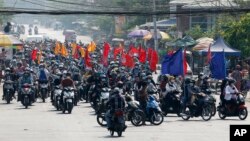 Demonstran antikudeta mengendarai sepeda motor dan membawa bendera dalam aksi protes di Mandalay, Myanmar Kamis (25/3). 