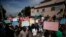 FILE - Several hundred protesters march carrying signs in Creole calling for President Jovenel Moïse to resign, in Port-au-Prince, Haiti, Oct. 21, 2019.