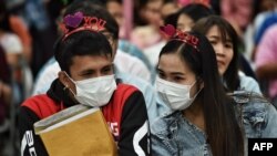 គូស្នេហ៍​មួយ​គូ​ពាក់​ម៉ាស់​រង់ចាំ​ចុះ​ឈ្មោះ​ស្នើ​សុំ​សំបុត្រ​អាពាហ៍ពិពាហ៍ នៅ​ក្នុង​ស្រុក Bang Rak ក្នុង​ក្រុង​បាងកក កាលពី​ថ្ងៃទី១៤​ ខែកុម្ភៈ ឆ្នាំ២០២០។