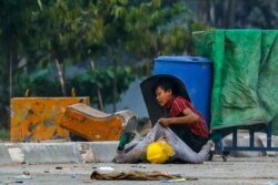 A protester holds onto the shirt of a fallen demonstrator during a crackdown by security forces on anti-coup protests in Hlaing Tharyar township in Yangon, Myanmar, March 14, 2021.