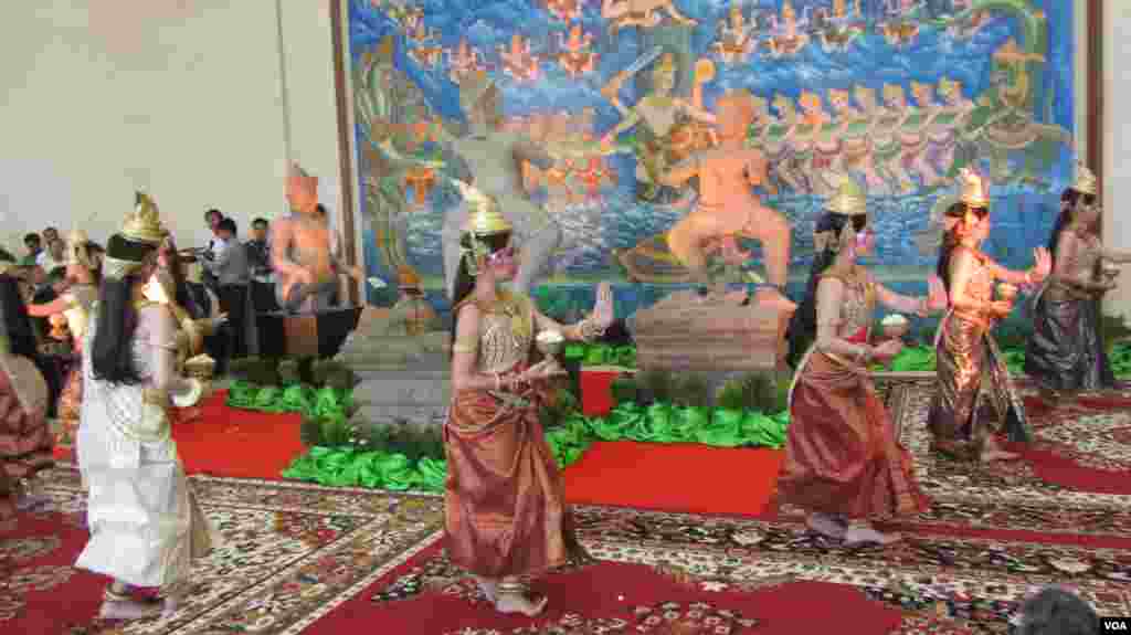 Dancers perform near three pieces of the 10th century Cambodian sandstone statues from the United States, during a handover ceremony at the Council of Ministers, in Phnom Penh, June, 3, 2014. (VOA Khmer)