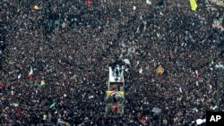 Coffins of Gen. Qassem Soleimani and others who were killed in Iraq by a U.S. drone strike, are carried on a truck surrounded by mourners during a funeral procession, in the city of Mashhad, Iran, Jan. 5, 2020.