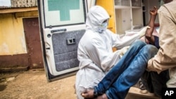 In this Wednesday, Sept. 24, 2014 file photo, health workers load a suspected Ebola patient into the back of an ambulance in Freetown, Sierra Leone. (AP Photo/Michael Duff, File)