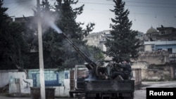 一名叙利亚自由军战士2012年12月23日在叙利亚政府军在伊德利卜附近发动空袭行动时候，使用高射炮向政府军战机开火