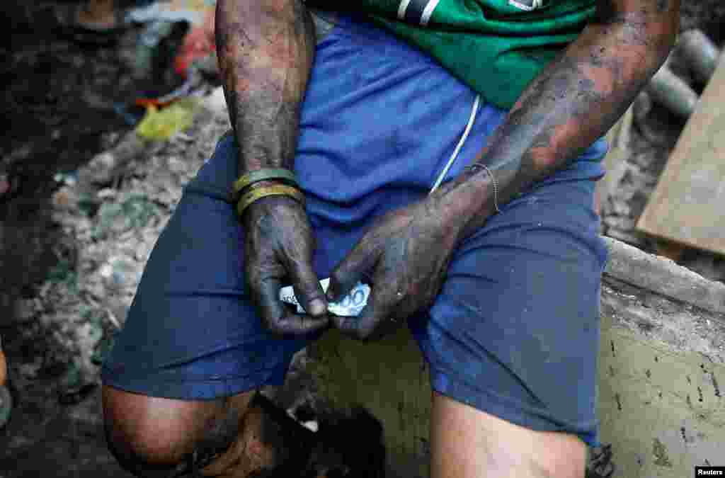 A man holds money he earned by selling recycled materials from his burnt house after a fire in the residential district of Addition Hills in Mandaluyong, Metro Manila, Philippines.