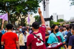 FILE - A protester holds up the three-finger salute, a sign of defiance, during anti-government protests in Bangkok, Thailand, June 26, 2021. (Tommy Walker/VOA)