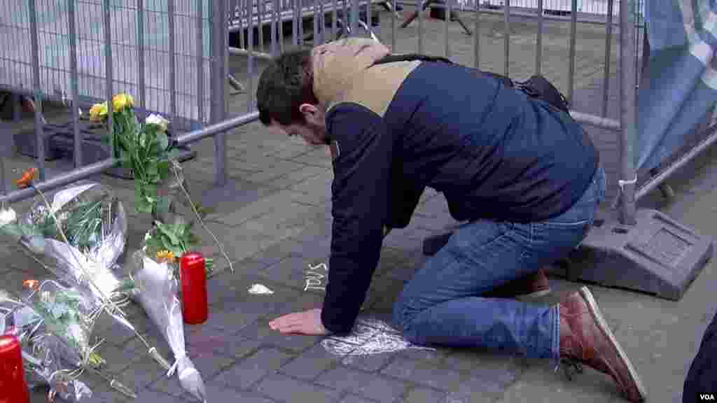 A man leaves a message on the sidewalk outside the Moelenbeek metro station in Brussels, March 24, 2016. (L. Bryant/VOA)