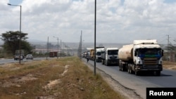 FILE - Trucks drive along the main road from the port city of Mombasa in the outskirts of Kenya's capital, Nairobi, March 4, 2016.