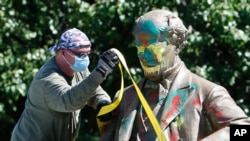 A worker secures the statue of Confederate Naval officer Matthew Fontaine Maury to a truck on Monument Avenue, in Richmond, Va., July 2, 2020.