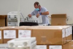 FILE - Arizona election officials count ballots for the general election inside the Maricopa County Recorder's Office, Nov. 6, 2020, in Phoenix.