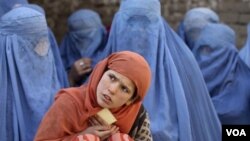 Seorang gadis Afghanistan bersama para perempuan Afghan lainnya menunggu distribusi makanan di tempat penampungan "KinderBerg International" bantuan pemerintah Jerman di Kunduz (foto: dok.).