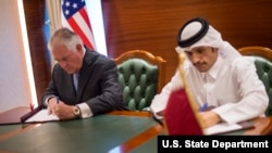 Sakataren ma'aikatar harkokin tsaron Amurka Rex Tillerson da ministan harkokin kasashen ketare na Qatar Sheikh Mohammed bin Abdulrahman Al Thani suna sa hannu a yarjejeniya MOU a Doha, Qatar, July 11, 2017. 