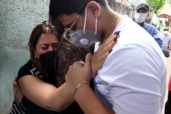 Journalist Lidieth Diaz, left, wife of Honduran journalist David Romero, the head of Globo radio and TV station who was sentenced in 2019 to nearly 11 years in prison for defamation, cries after he recently died of complications from COVID-19.