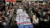 Flag-draped caskets of those who died in Saturday's terror attack on a military parade are laid out during a mass funeral, in the southwestern city of Ahvaz, Iran, Sept. 24, 2018. 