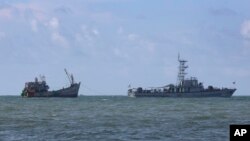 Kapal angkatan laut Myanmer menarik sebuah kapal migran dekat pulau Thameehla (31/5).