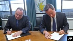 Pimpinan Partai Nasional Skotlandia yang berkuasa, Alex Salmond (kiri) menandatangani kesepakatan referendum kemerdekaan dengan PM Inggris David Cameron (15/10).