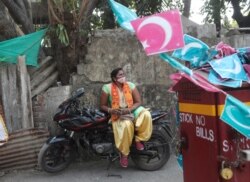 A Bharatiya Janata Party supporter wearing mask rests on bike as she waits to take part in a protest against The Amazon Prime Video web series Tandav in Mumbai, India, Jan 19, 2021.