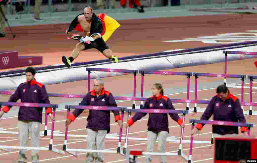 Germany's Robert Harting jumps over a hurdle as he celebrates winning the men's discus throw final. Harting won gold ahead of Iran's Ehsan Hadadi who took silver and Estonia's Gerd Kanter who won bronze.