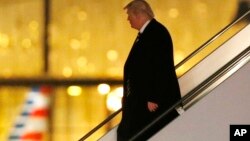 President-elect Donald Trump walks down the stairs from his plane after returning from Wisconsin to LaGuardia Airport, Dec. 13, 2016, in New York.