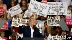 Presiden Donald Trump mengangkat tangan sambil mengepalkannya di depan para pendukungnya di akhir kampanye rapat besar hari Sabtu, 18 Februari 2017, di Melbourne, Florida. (foto: AP Photo/Chris O'Meara)
