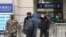Security officers check a person at an entrance to the Hankou Railway Station in Wuhan in central China's Hubei Province, Jan. 23, 2020.