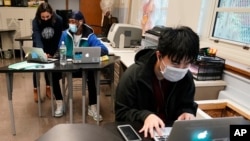 FILE - Students navigate an online lesson with the help of an instructor, at West Brooklyn Community High School in New York City, Oct. 29, 2020. 