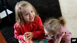 Coy Mathis (kiri) bermain dengan adiknya Auri di rumah mereka di Fountain, Colorado. Coy didiagnosa mengalami gangguan identitas gender dan merasa sebagai perempuan meski dilahirkan sebagai laki-laki. (AP/Brennan Linsley)