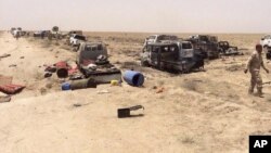 Iraqi security forces inspect vehicles belonging to escaping Islamic State militants outside Fallujah, Iraq, Wednesday, June 29, 2016.