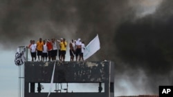 Inmates at the Puraquequara prison stand on a water tower as they protest against bad conditions and restrictions on family visits put in place to curb the spread of the new coronavirus in Manaus, Brazil, May 2, 2020. 