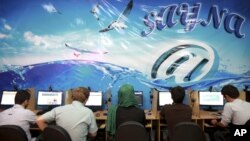 FILE - In this Tuesday, Sept, 17, 2013 file photo, Iranians surf the Internet at a cafe in Tehran, Iran. In Iran, a government push for a 'halal' internet means more control after protests. (AP Photo/Ebrahim Noroozi, File)