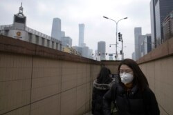 Residents walk out of a subway station in Beijing, March 9, 2020. With almost no new COVID-19 cases being reported in Beijing, workers are slowly returning to their offices with masks on and disinfectant in hand.