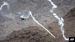 Helikopter pasukan koalisi melancarkan serangan udara ke sekeliling sebuah bangunan (tak terlihat), yang diyakini sebagai hunian para pejuang Taliban di Kuz Kunar, Nangarhar, Afghanistan, 17 Juli 2011. (Foto: dok). 