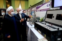 FILE - Iranian President Hassan Rouhani reviews his country's nuclear achievements, in Tehran, April 10, 2021. ​The Biden administration is weighing a rollback of some Trump-era sanctions imposed on Iran to encourage compliance with a nuclear pact.