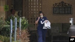 A worker at the Life Care Center in Kirkland, Wash., near Seattle, wears a mask as she leaves the building, Monday, March 2, 2020. 