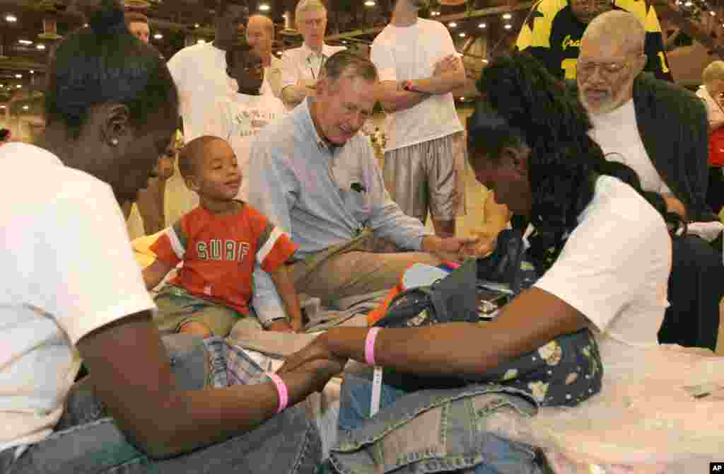 Mantan Presiden George H.W. Bush berdoa bersama pengungsi Badai Katrina Rebecca Solomon (kiri) Terrill Hoskins, 3, LaShonda Hoskins dan Ernie Ladd di Reliant Center yang bersebelahan dengan Astrodome di Houston, 5 September 2005.