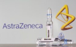 A test tube labeled with the vaccine is seen in front of AstraZeneca logo in this illustration taken, Sept. 9, 2020.