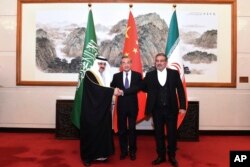 علی شمخانی، دبیر شورای عالی امنیت ملی جمهوری اسلامی ایران (راست)، با مساعد بن محمد العیبان، مشاور امنیت ملی عربستان سعودی (چپ)، و وانگ یی، عالی‌رتبه‌ترین دیپلمات چین (وسط) در یک نشست غیرعلنی در پکن که روز شنبه ۲۰ اسفند ۱۴۰۱ برگزار شد، دست می‌دهند.