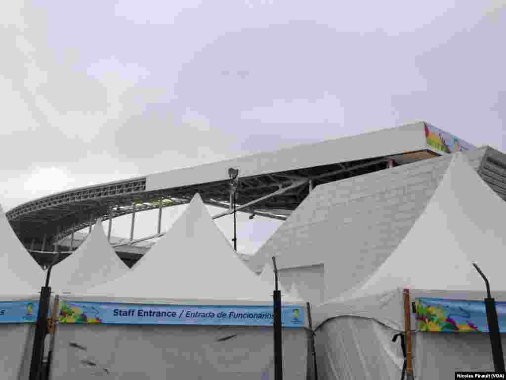 Workers frantically try to finish sections of the stadium although the roof construction may not be completed until after the competition ends, Sao Paulo, June 10, 2014. (VOA/Nicolas Pinault)