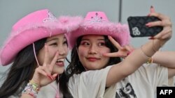 แฟนเพลงของ 'เทย์เลอร์ สวิฟต์' หรือ "สวิฟตีส์" ในญี่ปุ่น ถ่ายรูปด้านหน้าโตเกียวโดม ก่อนคอนเสิร์ตทัวร์เอเชียของสวิฟต์จะเริ่มขึ้นที่กรุงโตเกียว วันที่ 7 ก.พ. 2024 (เอพี) 