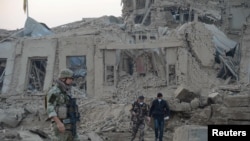 Pasukan keamanan Afghanistan dan tentara NATO memeriksa lokasi ledakan di dekat konsulat Jerman di Mazar-i-Sharif, Afghanistan, 11 November 2016 (REUTERS/Anil Usyan)
