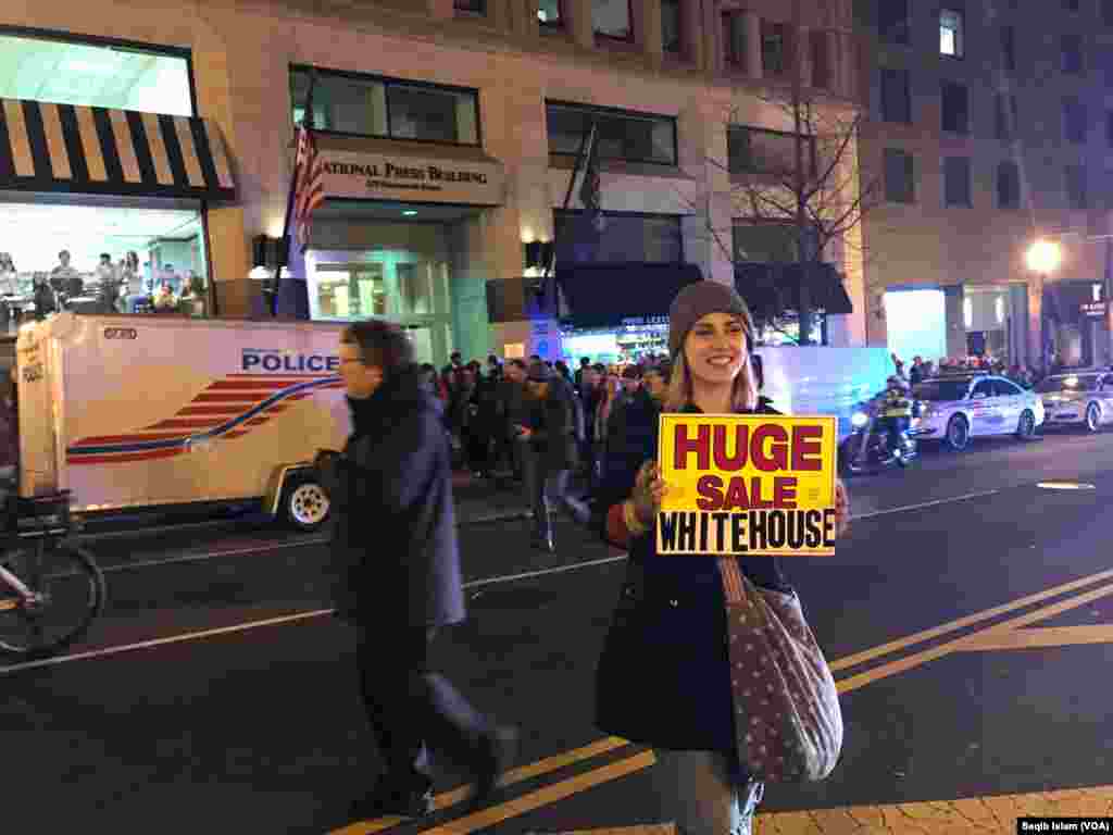 Outside the National Press Club in Washington, D.C., a young woman holds an anti-Trump protest sign, Jan. 19, 2017. 