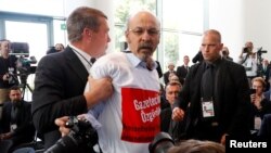 Turkish journalist Ertugrul Yigit from Avrupa Postasi is removed by the security guards during a news conference of German Chancellor Angela Merkel and Turkish President Tayyip Erdogan at the chancellery in Berlin, Germany, September 28, 2018. REUTERS/Fabrizio Bensch 
