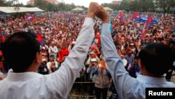 រូបឯកសារ៖ លោក សម រង្ស៊ី (ឆ្វេង) និងលោក កឹម សុខា (ស្តាំ) ស្វាគមន៍អ្នកគាំទ្រគណបក្សក្នុងព្រឹត្តិការណ៍បាតុក​ម្មមួយនៅទីលានប្រជាធិបតេយ្យ រាជធានីភ្នំពេញ ថ្ងៃទី១៦ ខែធ្នូ ឆ្នាំ២០១៣។