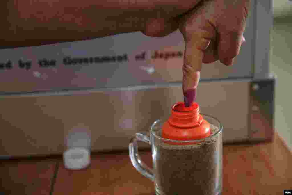 ដៃ​មន្ត្រី​ក្រុម​ប្រឹក្សា​សង្កាត់​មួយ​រូប​ត្រូវ​បាន​ដាក់​ឱ្យ​ជ្រលក់​ទឹក​ថ្នាំ ​ក្នុង​​ការិយាល័យ​​បោះ​ឆ្នោត​​ព្រឹទ្ធ​សភា​​មួយ​​​កន្លែង​​នៅ​​ក្រុង​​ភ្នំពេញ ​កាលពីថ្ងៃទី២៥ ​ខែកុម្ភៈ ​ឆ្នាំ២០១៨។ ​(អូន ឆេងប៉រ/VOA)