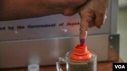 រូបឯកសារ៖ ដៃ​មន្ត្រី​ក្រុម​ប្រឹក្សា​សង្កាត់​មួយ​រូប​ត្រូវ​បាន​ដាក់​ឱ្យ​ជ្រលក់​ទឹក​ថ្នាំ ​ក្នុង​​ការិយាល័យ​​បោះ​ឆ្នោត​​ព្រឹទ្ធ​សភា​​មួយ​​​កន្លែង​​នៅ​​ក្រុង​​ភ្នំពេញ ​កាលពីថ្ងៃទី២៥ ​ខែកុម្ភៈ ​ឆ្នាំ២០១៨។ ​(អូន ឆេងប៉រ/VOA)