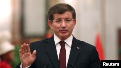 FILE - Turkey's Prime Minister Ahmet Davutoglu speaks to reporters in Baghdad, Nov. 20, 2014.