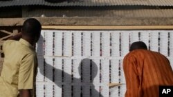 Voters check their names on a list before casting their ballot at a polling station in N'djamena, Chad, April 11, 2021. 